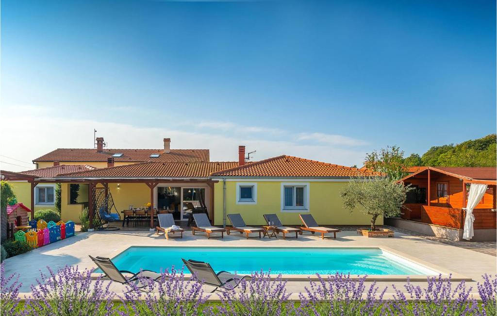 a villa with a swimming pool and a house at Amazing Home In Loborika With Heated Swimming Pool in Loborika