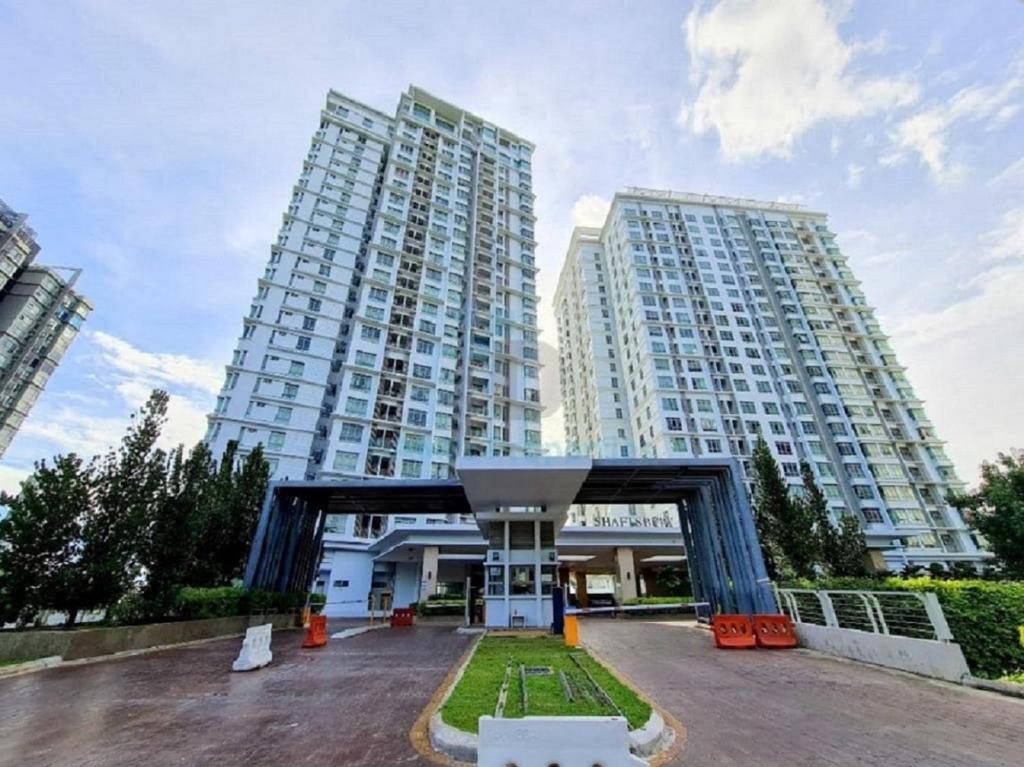 a large building with two tall buildings in the background at Shaftsbury residence cyberjaya studio suites with free parking in Cyberjaya