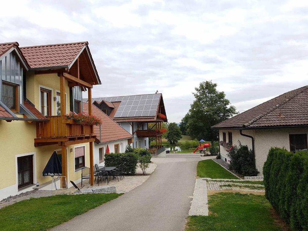 kręta droga między dwoma domami z panelami słonecznymi w obiekcie Kollerhof w mieście Neunburg vorm Wald