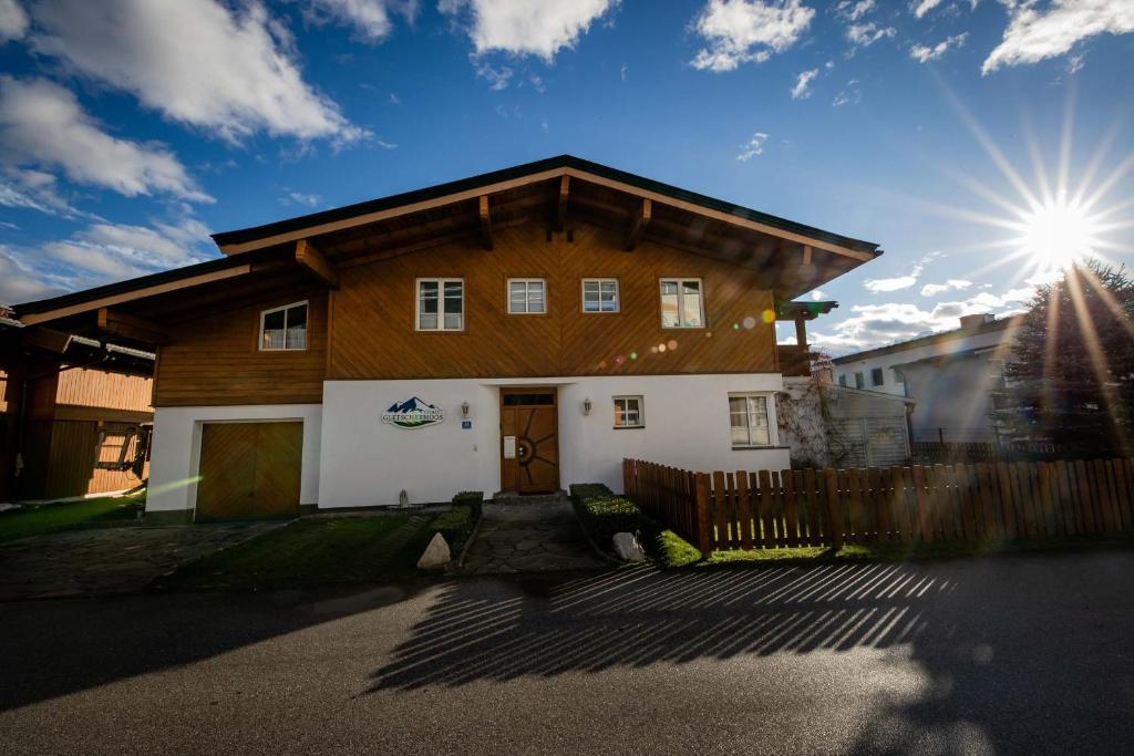 ein großes Holzhaus mit der Sonne am Himmel in der Unterkunft Chalet Gletschermoos in Zell am See