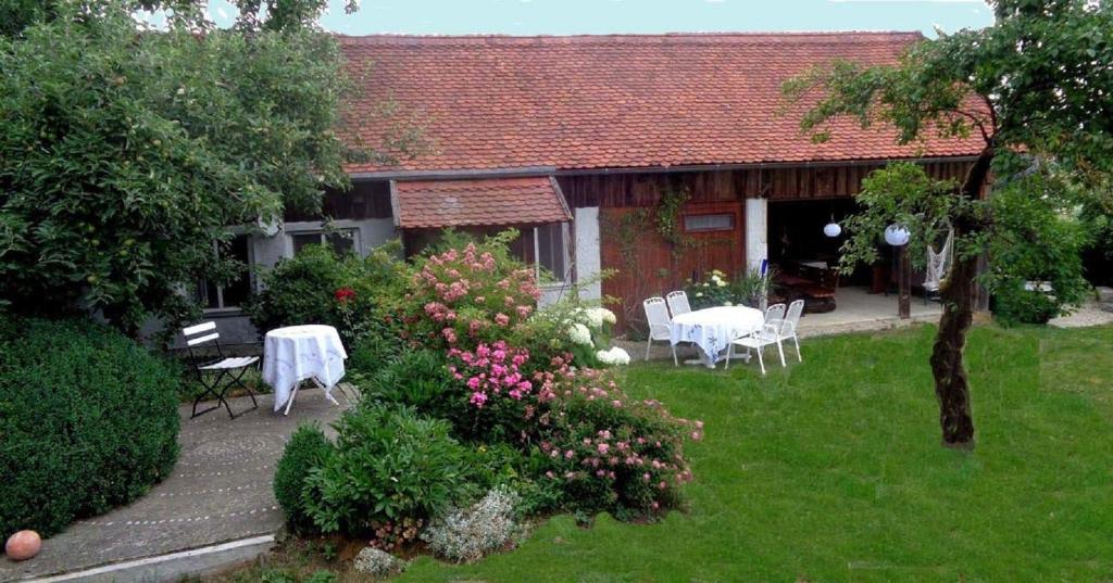 ein Haus mit einem Tisch und Stühlen im Hof in der Unterkunft Ferienwohnung Kuschel in Thanstein