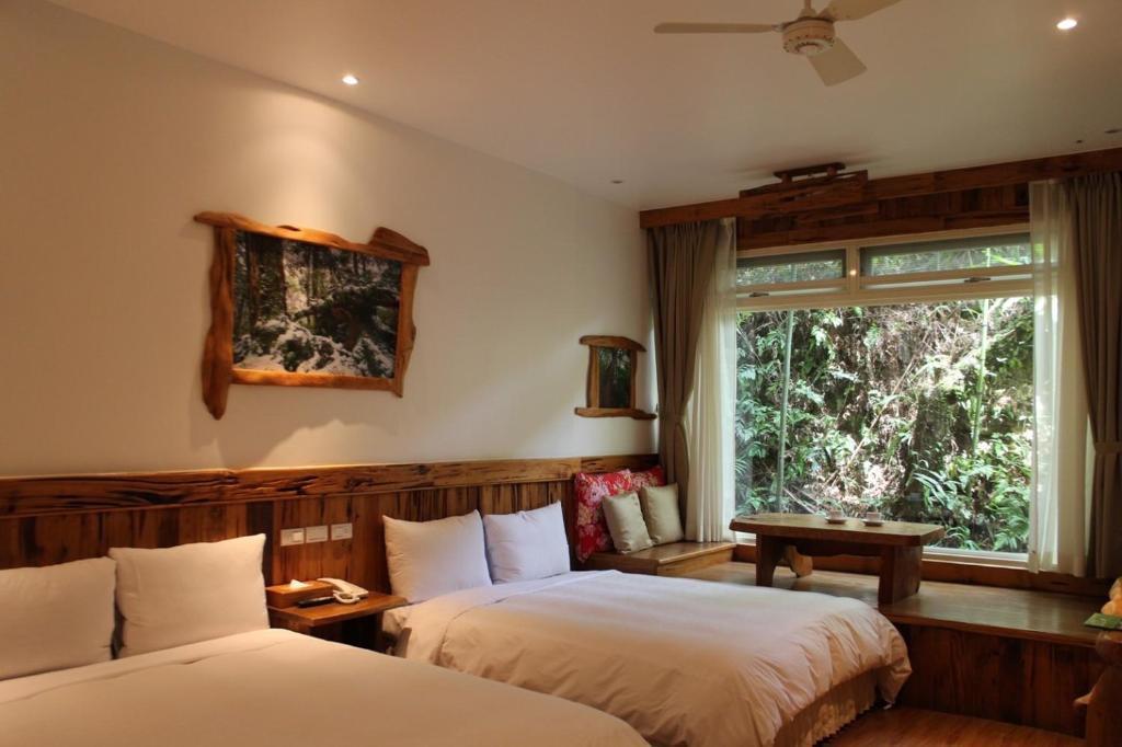 2 Betten in einem Zimmer mit Fenster in der Unterkunft Shangrila Leisure Farm in Dongshan