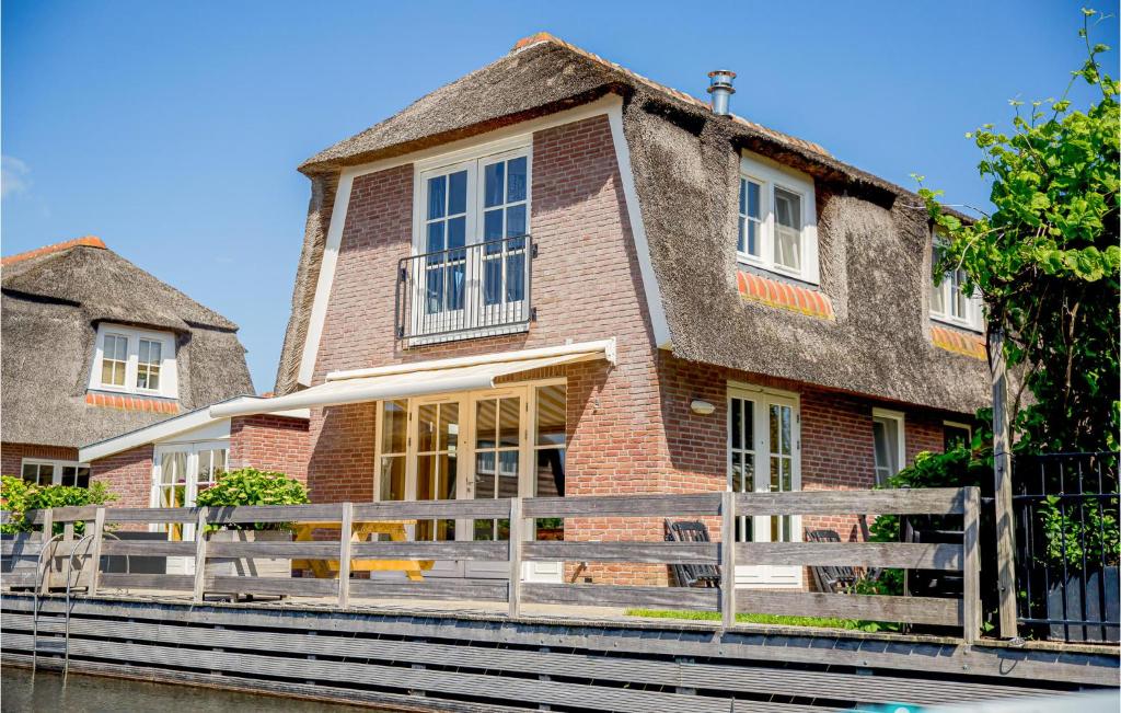 ブリューケレンにあるPet Friendly Home In Breukelen With House Sea Viewの塀の前のレンガ造りの家