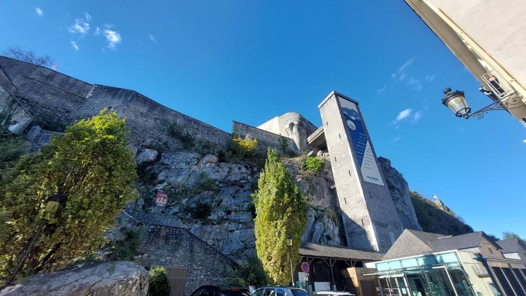un bâtiment à flanc de montagne dans l'établissement STUDIO MEUBLÉ AU PIED DU CHATEAU, à Lourdes