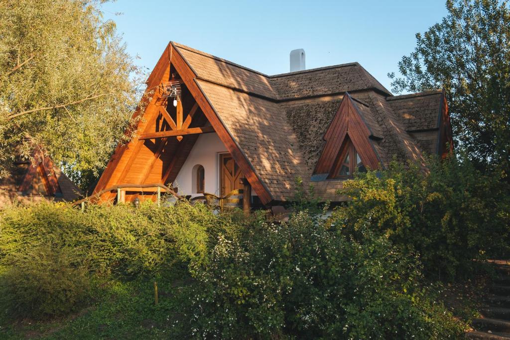 uma casa com um telhado de gambrel ao lado dela em Kormorán Vendégház em Tiszafüred