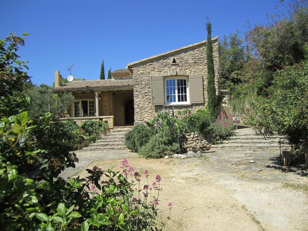 une maison en pierre avec un chemin menant à celle-ci dans l'établissement le murmure des oliviers, à Castillon-du-Gard