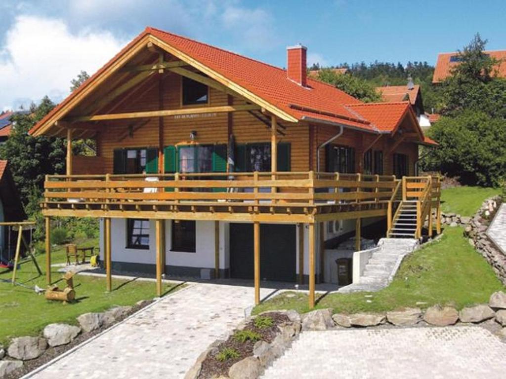 ein großes Holzhaus mit einer großen Terrasse in der Unterkunft Berghaus Julia in Sankt Englmar