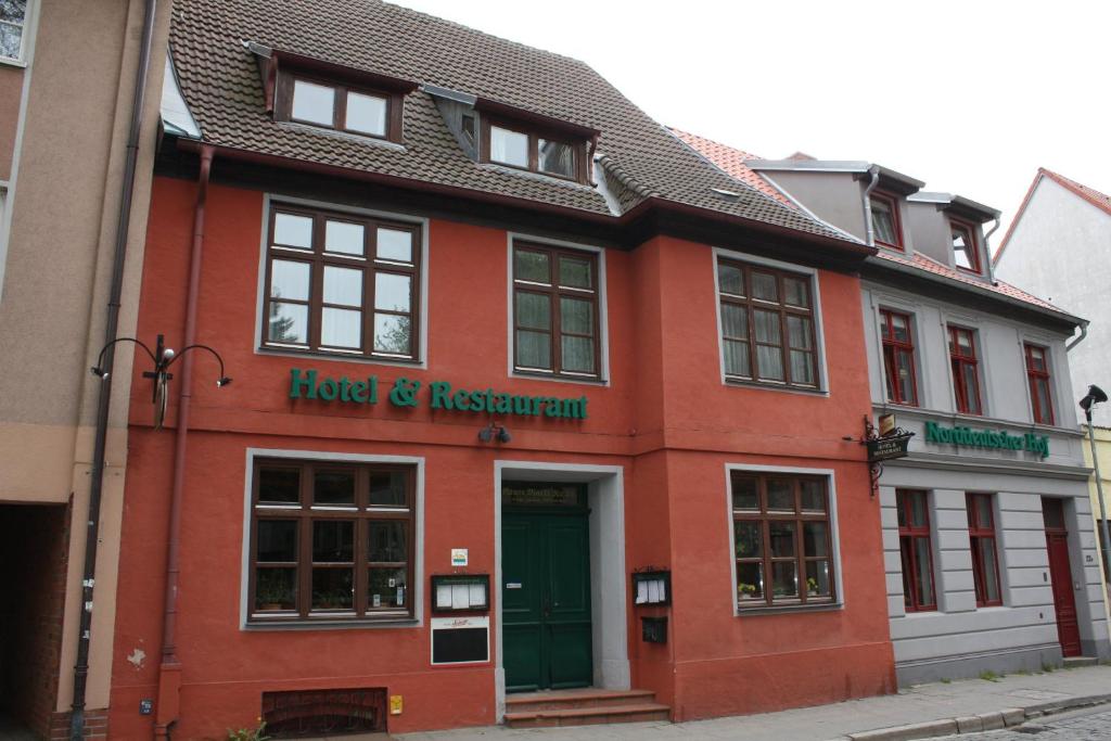 un bâtiment rouge avec un hôtel et un restaurant dans une rue dans l'établissement Norddeutscher Hof, à Stralsund