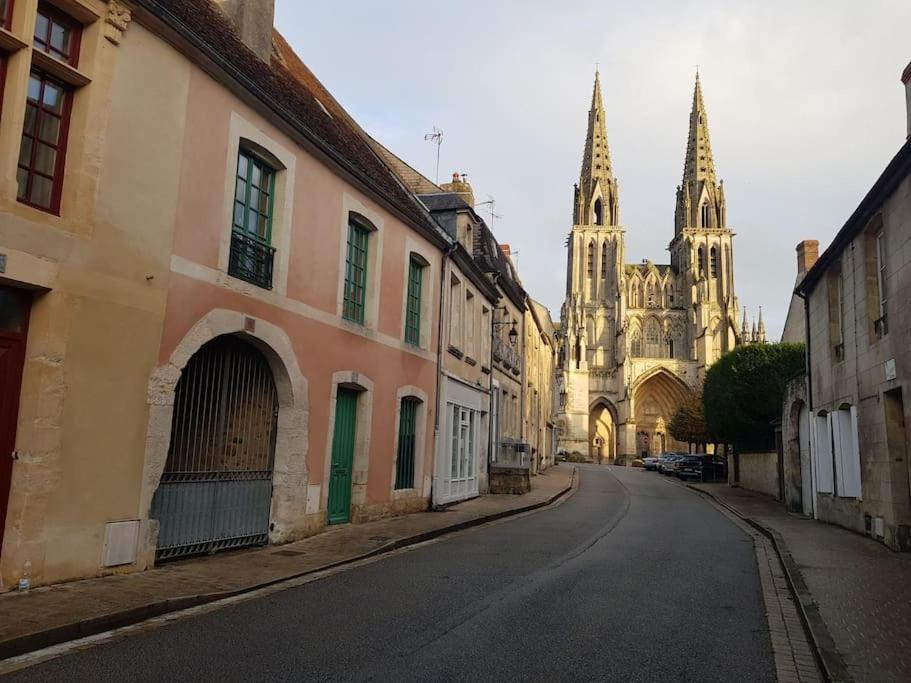 eine leere Stadtstraße mit einer Kathedrale im Hintergrund in der Unterkunft Le petit Conté - Maison calme en centre ville in Sées
