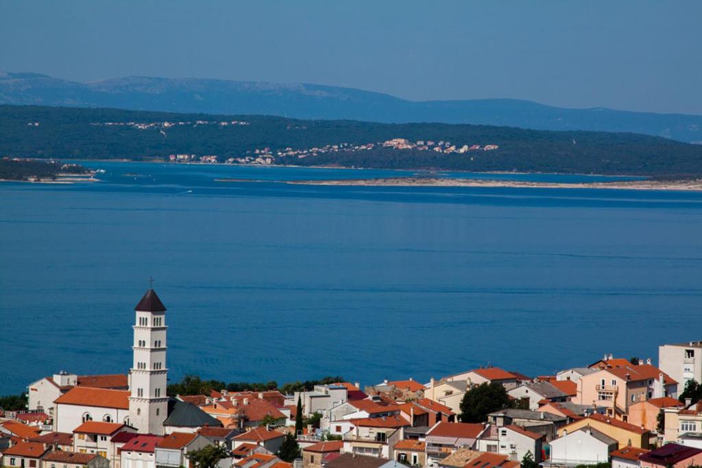 a view of a town with a lighthouse and the water at Apartments Villa San Antonio in Crikvenica