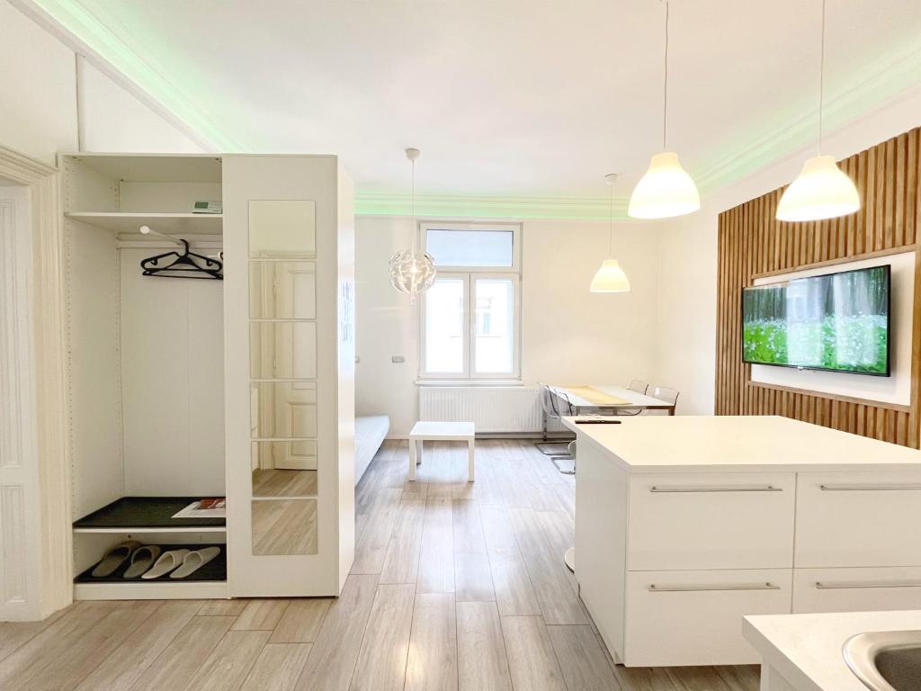 een keuken met witte kasten en een woonkamer bij Agape Apartments in Zagreb