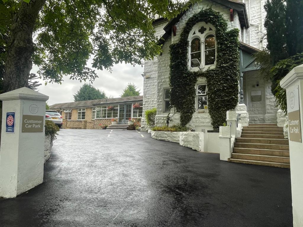 a house with a driveway in front of a building at Mansfield Lodge Hotel Ltd in Mansfield