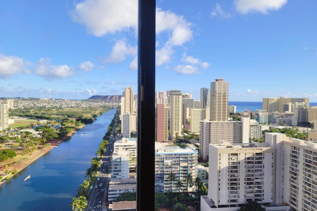 a view of a river in a city with buildings at Waikiki Condo High Floor Views Beaches Convention Center in Honolulu