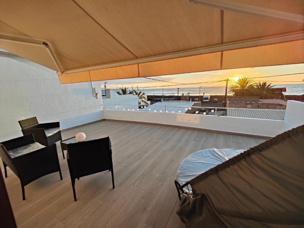 a room with a table and chairs on a roof at Casa Uwe, El Remo in Puerto Naos