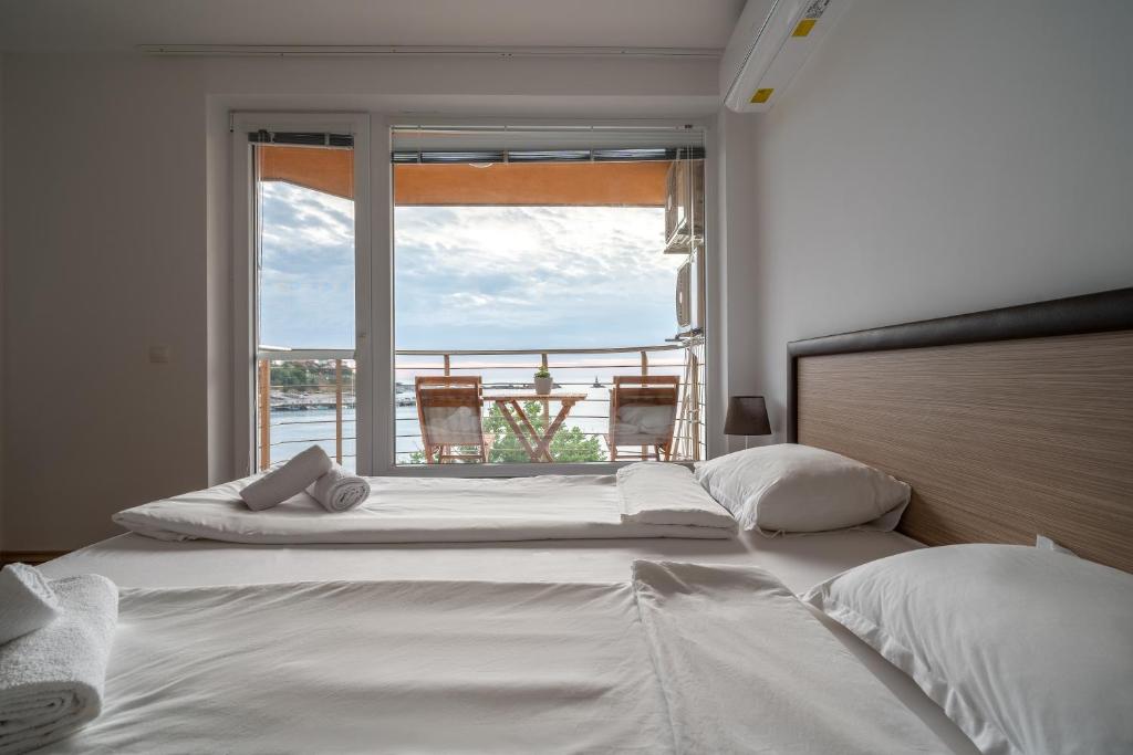 a bedroom with a large bed with a large window at Moana Lighthouse Apartment in Ahtopol