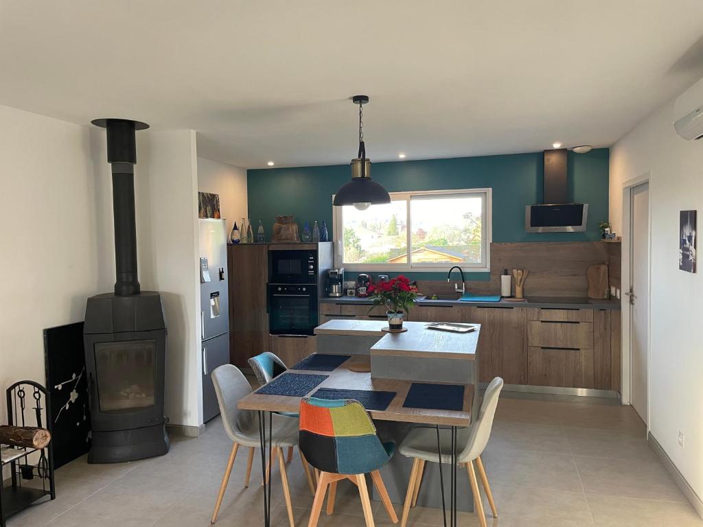 a kitchen with a table and chairs and a stove at Au Clos Decoeur in Salaise-sur-Sanne