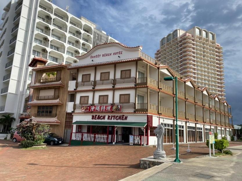 duży budynek z światłem ulicznym przed nim w obiekcie サンセットビーチホテル w mieście Chatan