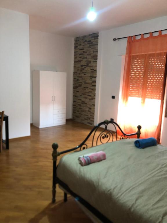 1 dormitorio con 1 cama en una habitación con ventana en Casa Alighieri, en Montalto Uffugo