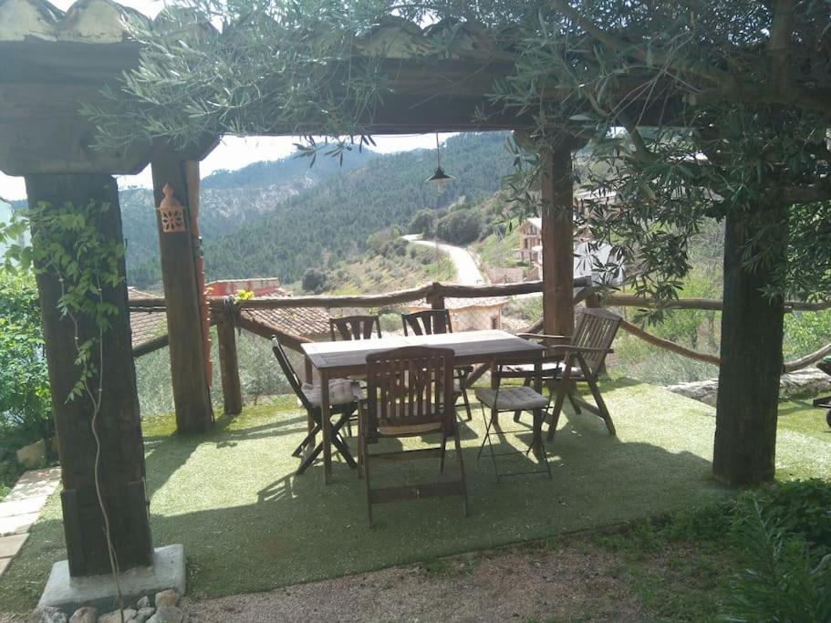 a table and chairs under a pergola with a view at A 11 km de Riopar Casa Acogedora con sabor antaño in Cañada del Provencio