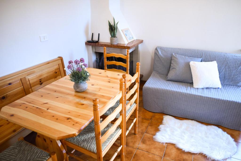 sala de estar con mesa de madera y sofá en Appartamento a Campo Felice - Treeffe en Collimento