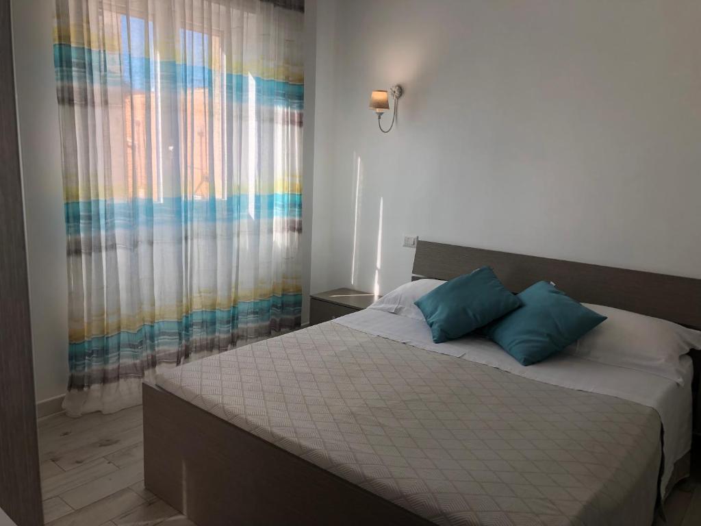 - un lit avec 2 oreillers bleus dans une chambre dans l'établissement Casa Vacanze De Nittis, à Barletta