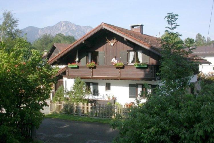 a house with a balcony with flowers on it at Ferienwohnung Heimbeck Kochel in Kochel