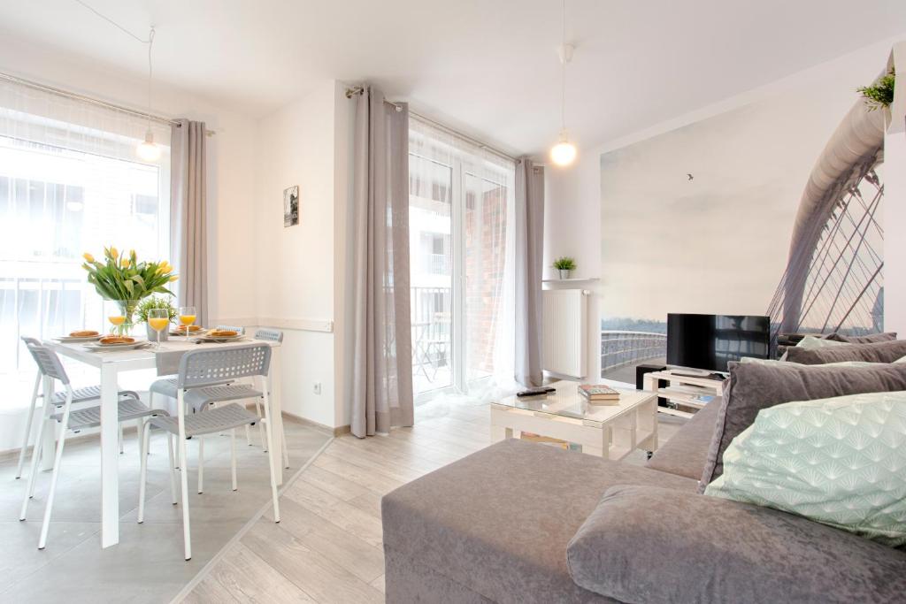 uma sala de estar com um sofá e uma mesa em Tyzenhauz Apartments Piwna Street em Cracóvia