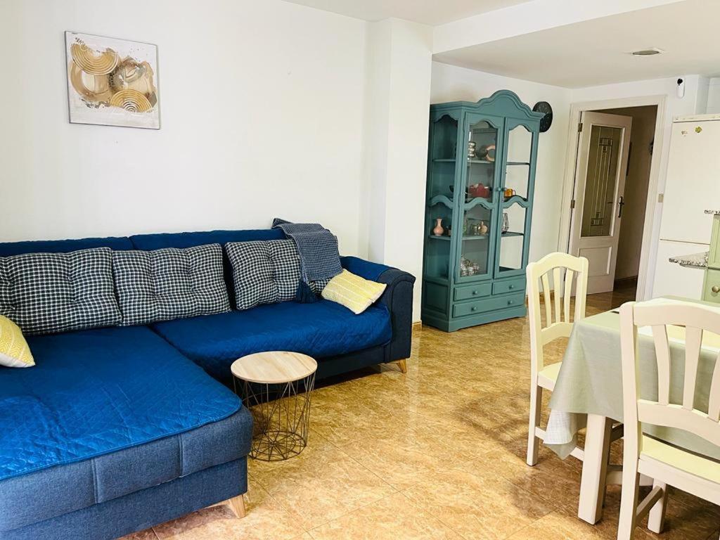 sala de estar con sofá azul y mesa en Beachfront apartment with a private garden on the ground floor, en Moncófar