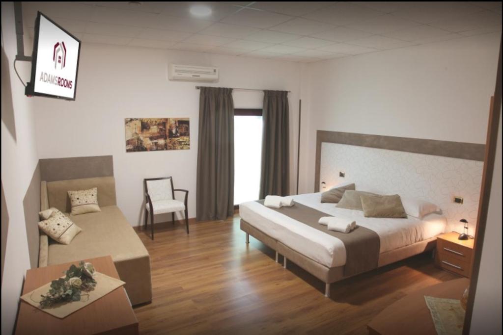 1 dormitorio con cama, escritorio y silla en Adams Rooms - Affittacamere en San Giovanni Lupatoto