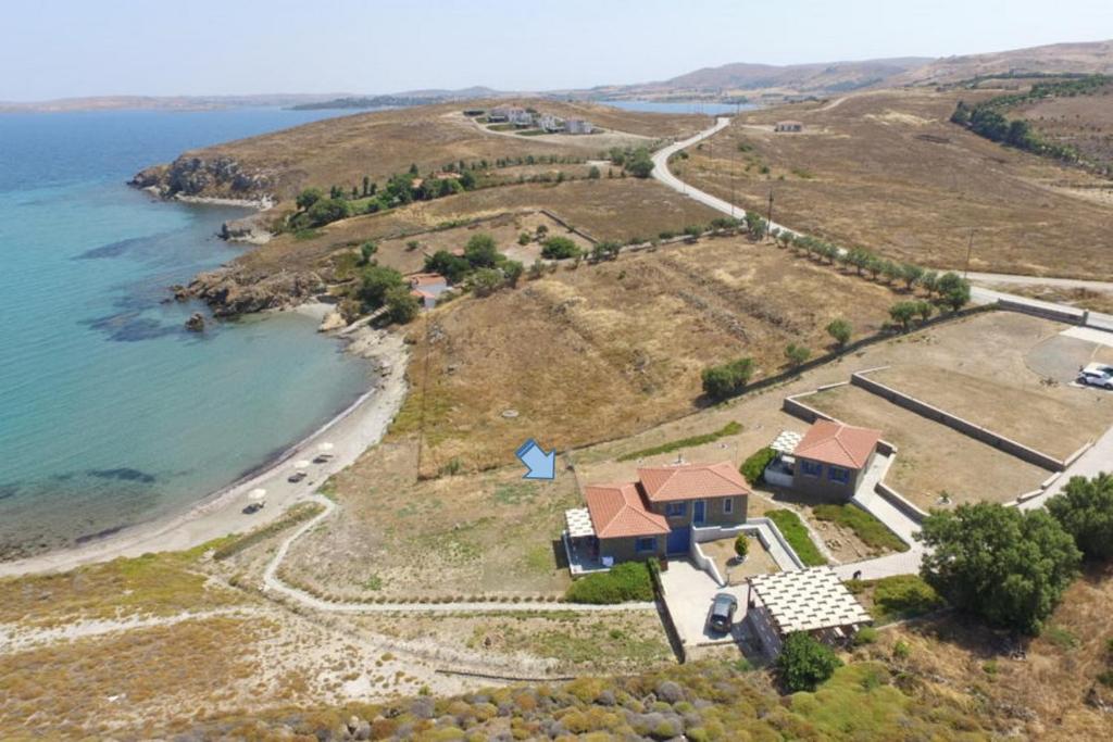 eine Luftansicht eines Hauses auf einem Hügel neben dem Meer in der Unterkunft Fanaraki Beach Studios in Mirina
