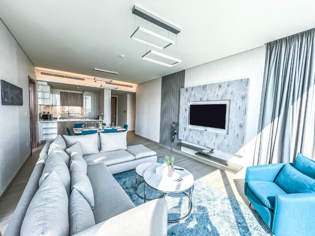 - un salon avec un canapé et une télévision dans l'établissement STAY Sensational 3BR Holiday Home near BurjKhalifa, à Dubaï
