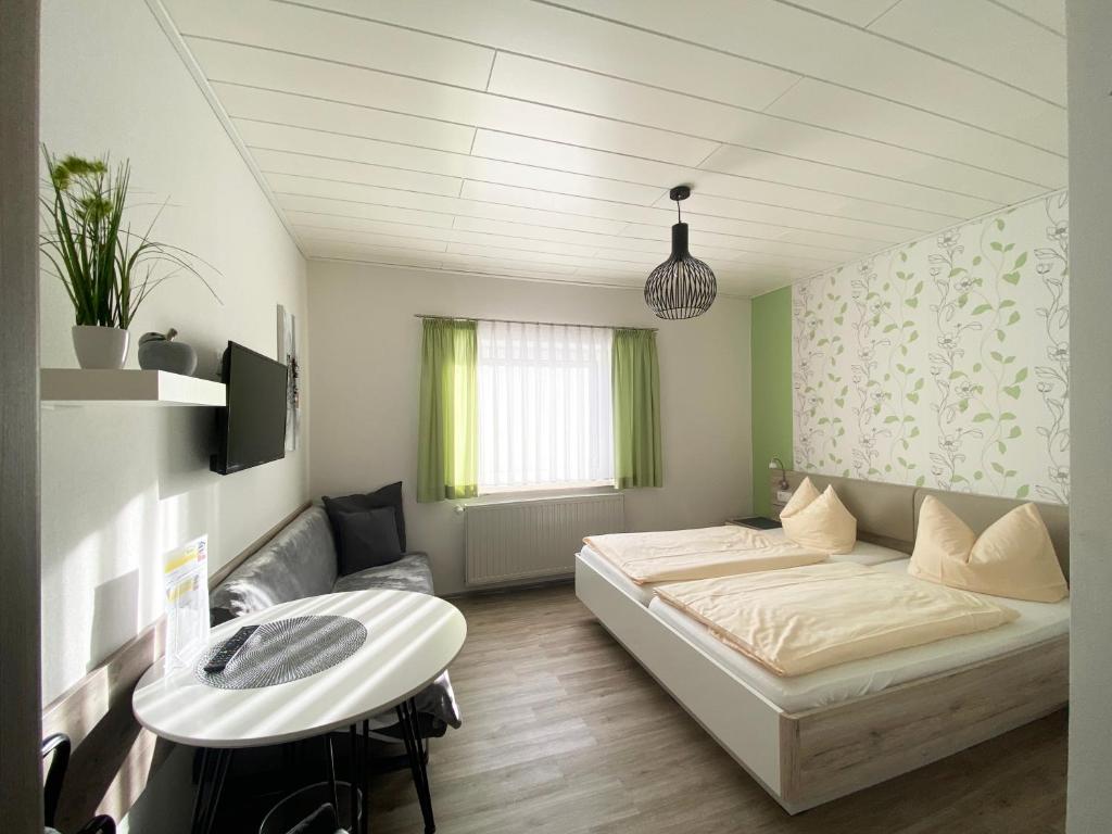 TannaにあるLandgasthof Kanzのベッドとテーブル付きの小さな部屋