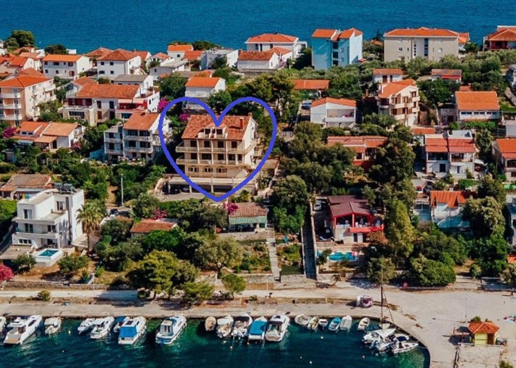 uma vista aérea de um resort com um coração pintado sobre ele em Seaside Apartments em Seget Vranjica