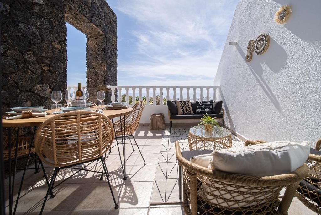 a patio with a table and chairs on a balcony at Casa Tucanes in Puerto del Carmen