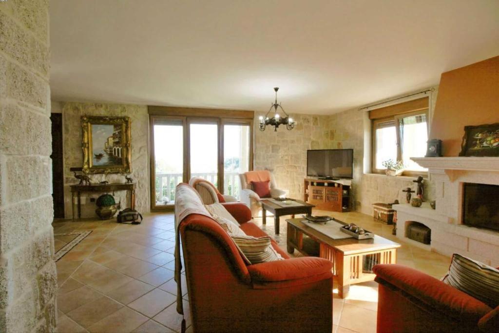 salon z kanapami i kominkiem w obiekcie Casa Os Castelos w mieście Monteviján