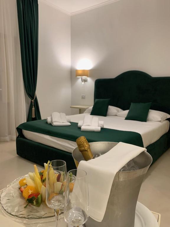 Habitación de hotel con cama y mesa con copas de vino en Villa Natia, en Mottola