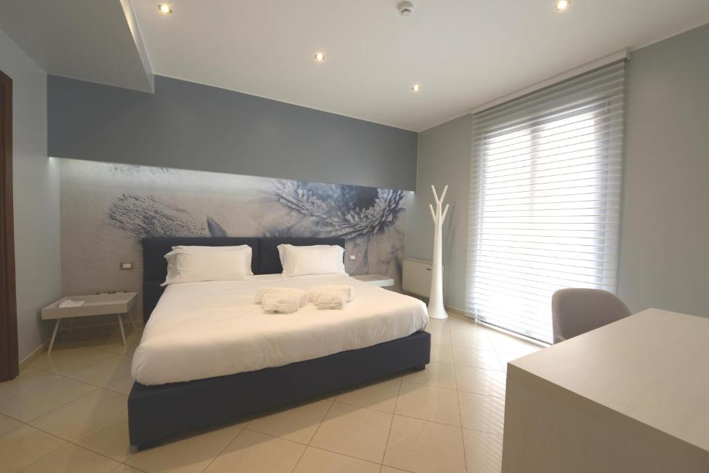 1 dormitorio con 1 cama con 2 toallas en Imperiali Hotel, en Francavilla Fontana