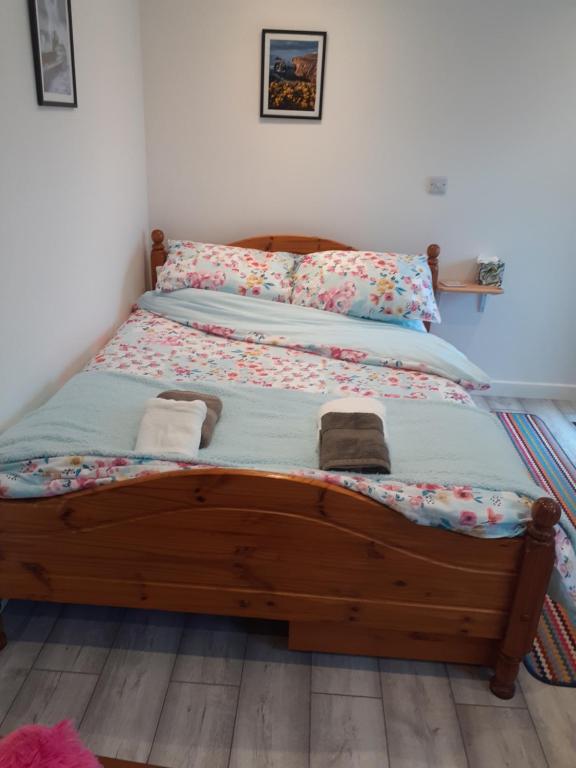 ein Bett mit einem Holzrahmen in einem Schlafzimmer in der Unterkunft Little Pedn in Penzance