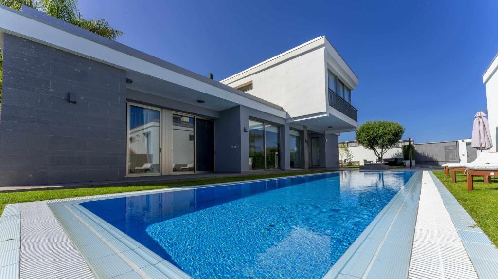 a swimming pool in front of a house at Luxury Villa Atlante con piscina climatiza privada in Santa Úrsula