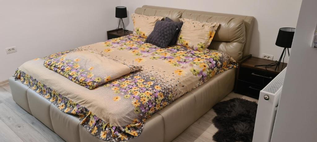 a bed covered in confetti with two pillows on it at Apartament cu 1 camera spatios ,luminos . in Cugir