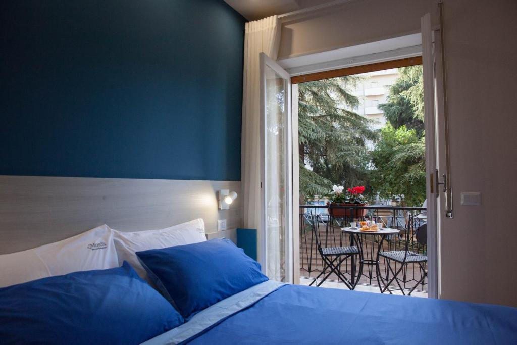 a bedroom with a bed and a balcony with a table at B&B Morelli Home in Cosenza