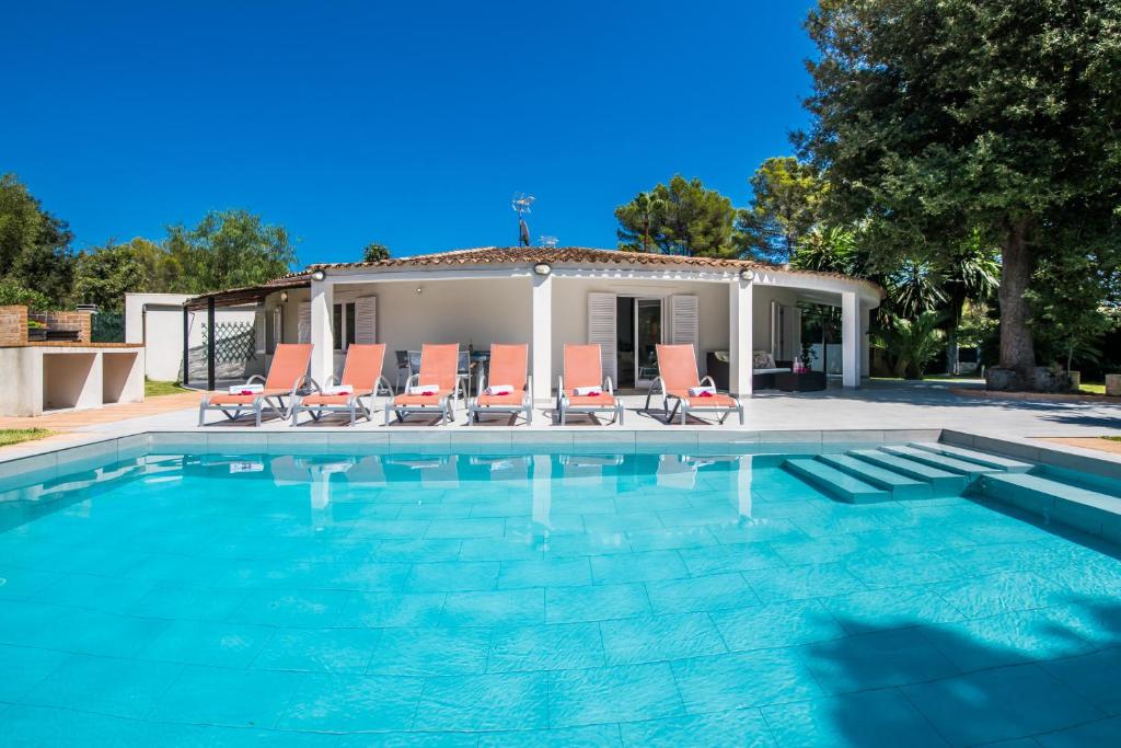 einen Pool mit Stühlen und ein Haus in der Unterkunft Casa Encinar in Crestatx