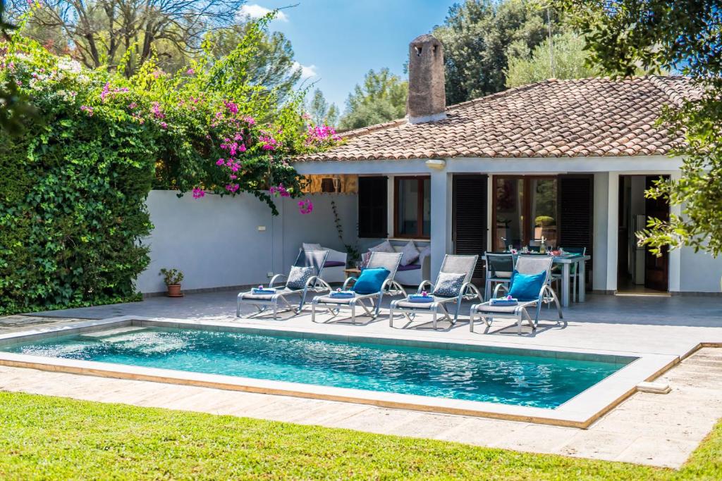 a pool with chairs and a table in front of a house at Ideal Property Mallorca - Casa Pequeña in Crestatx