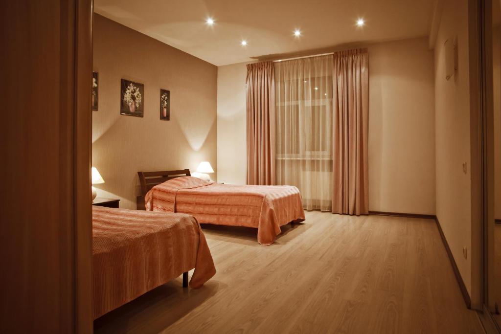 een hotelkamer met 2 bedden en een raam bij Apartments Nevsky 150 in Sint-Petersburg