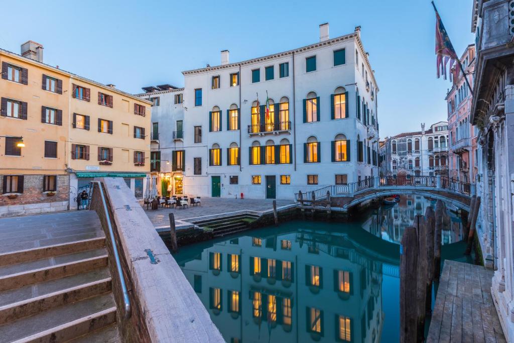 a canal in a city with buildings and a bridge at Palazzo Morosini Degli Spezieri - Apartments in Venice