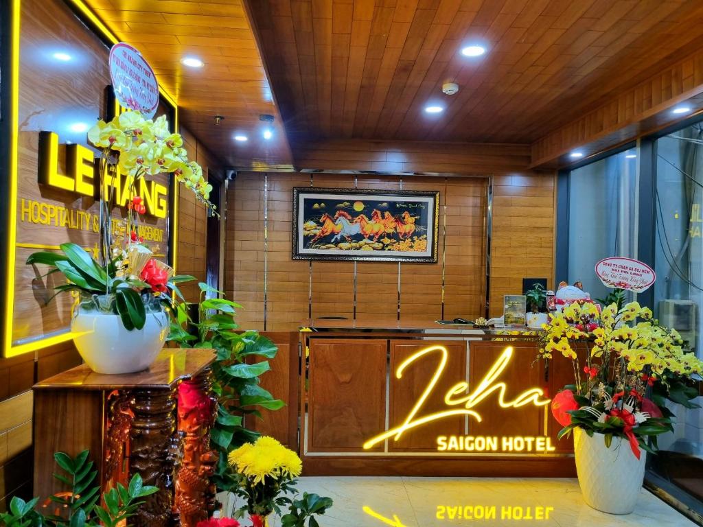 a restaurant with flowers in front of a counter at LEHA Saigon Hotel Airport in Ho Chi Minh City