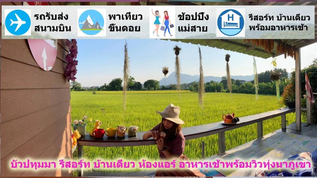 a woman in a hat sitting at a table in a field at Bua Patumma Resort in Mae Sai
