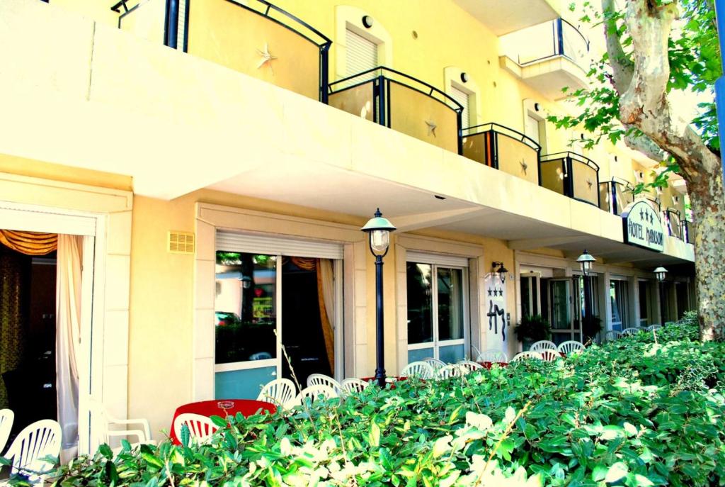 een gebouw met witte stoelen en een balkon bij Hotel Madison in Bellaria-Igea Marina