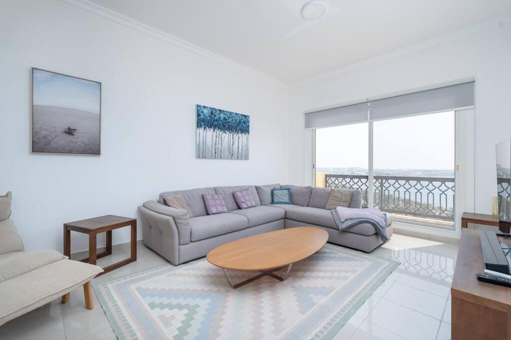 sala de estar con sofá y mesa en Stunning 2BD Sea View Apartment Private Beach Access en Ras al-Jaima