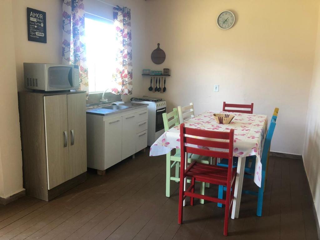 a kitchen with a table and chairs and a kitchen with a microwave at Casa do Porto - a 600m do Mar e da Lagoa in Florianópolis